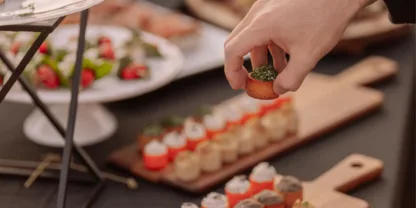 Image d'un buffet, une main qui prend une pièce cocktail